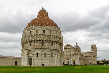 PISA, ITALY - OCTOBER 29, 2018: The Baptistery in the foreground, the Duomo in the center, and the leaning tower in the background on the right