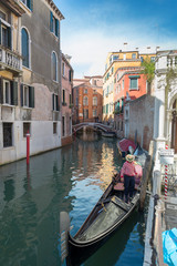 VENICE, ITALY- OCTOBER 30, 2018: Traditional narrow canal with gondolas in Venice, Italy