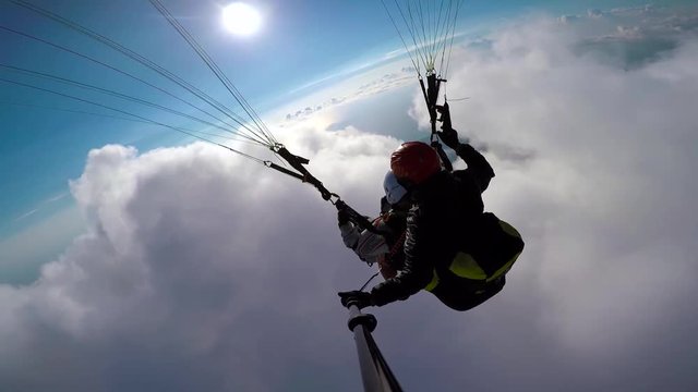 Man paragliders flying on paraplane in sky, clouds and skyline landscape. Point of view selfie action camera paragliders flying on paraplane. Active sport and extreme hobby.