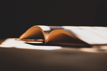 open book on wooden table and natural sun light , vintage look 