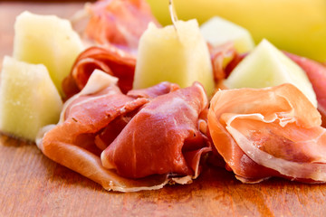 traditional Italian lunch  prosciutto and melon in an Italian restaurant in Florence , on a wooden table, italian food,  selective focus