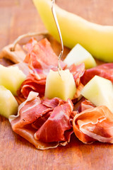 traditional Italian lunch  prosciutto and melon in an Italian restaurant in Florence , on a wooden table, italian food,  selective focus