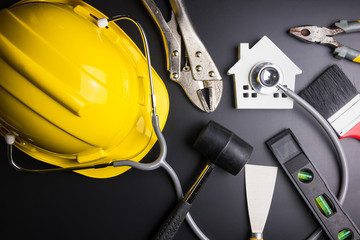 House model with stethoscope and construction tools on black background with copy space.Real estate concept, Repair maintenance concept isolated on black background.Indicates the health of the house.