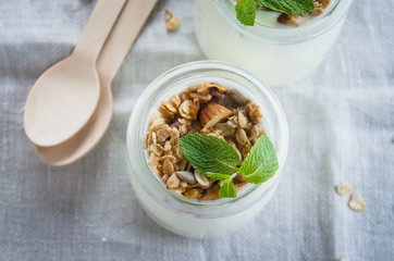 Homemade granola with greak yogurt in a glass jar. Healthy food concept. Top view, copy space