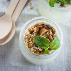 Homemade granola with greak yogurt in a glass jar. Healthy food concept. Top view, copy space