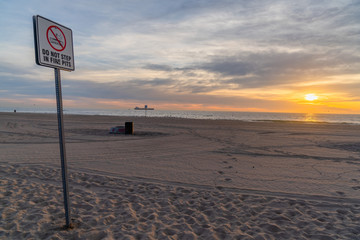 Do not step in fire pits sign on beach in sunset