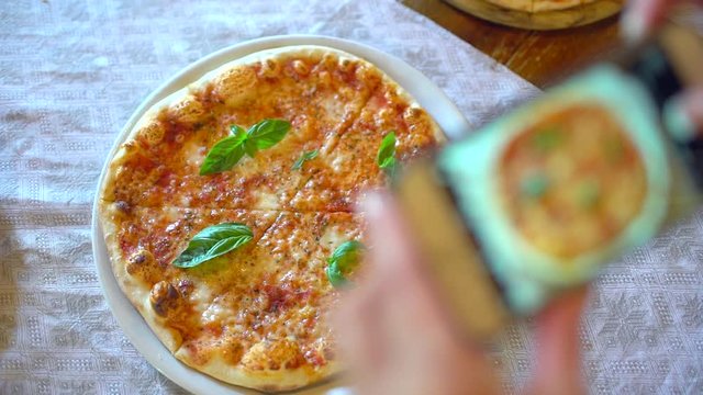 Woman in a restaurant make photo of food, pizza with mobile phone camera. Hands of female making a photo of pizza on a smartphone in cafe. Man Taking Food Photo of pizza into social networks. slow