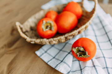 Persimmon fruits in a wicker basket. Agriculture and harvesting concept