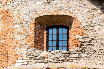 A small window in the thick wall of the medieval castle_