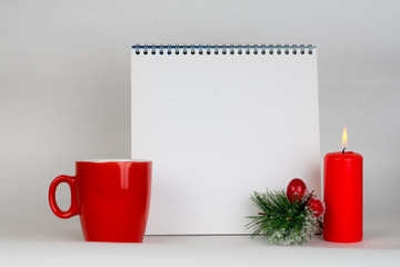 empty notebook with christmas decorations and red burning candle