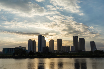 Fototapeta na wymiar the sun sets in the buildings across the Tama River Kawasaki Kanagawa Japan