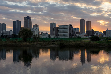 Fototapeta na wymiar the sun sets in the buildings across the Tama River Kawasaki Kanagawa Japan