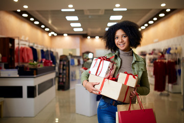 African american girl shopping gifts in mall on christmas sale. New year holidays concept. Smiling...