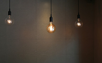 Hanging Lamp decor against gray tile wall background.