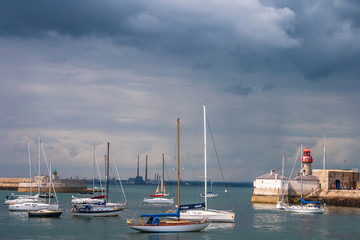 Fototapeta na wymiar Sailing boats and lighthouse in harbour of Dun Laoghaire, county Dublin, Ireland
