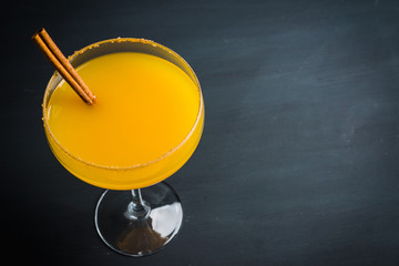 Tasty pumpkin margarita cocktail on the rustic background. Selective focus. Shallow depth of field.