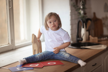 Naklejka premium baby with Down syndrome learns and plays