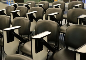 a lot of lecture chairs arranged in many rows in a building