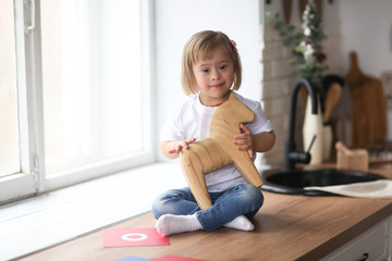 Toddler with Down syndrome plays with wooden horse
