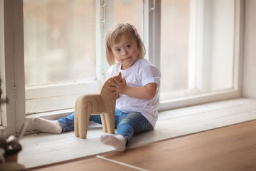 baby with Down syndrome plays with wooden toy