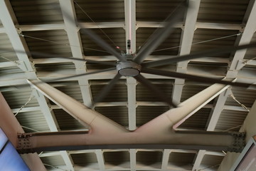 closeup picture of big fan fixed to the ceiling of sky train station