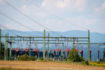 Fototapeta na wymiar High-voltage substation on mountains and blue sky background.
