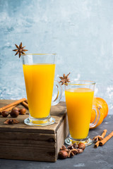 Hot pumpkin drink in glass on the rustic background. Selective focus. Shallow depth of field.