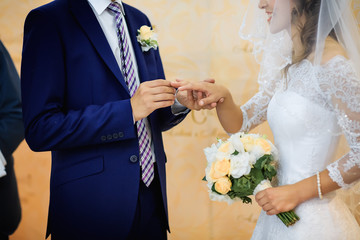 The touching moment of swapping wedding rings newlyweds. Wedding bouquet for bride