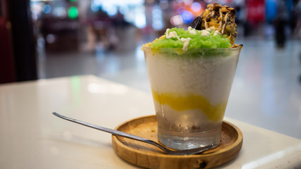 ฺBingsu Ice mango sticky rice In a glass cup on a table, Asian style.