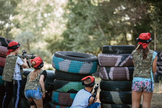 Kids playing lasertag on special polygon with shelter