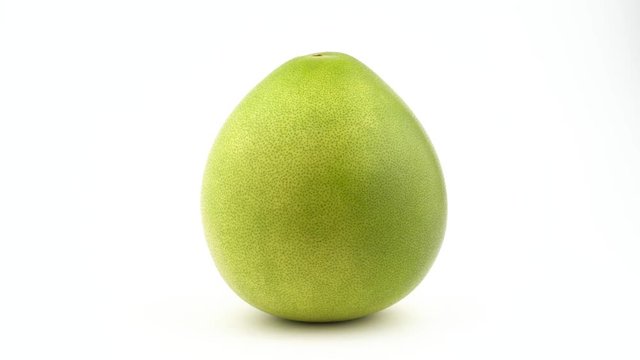 One whole big pomelo fruit. Rotating on the turntable. Isolated on the white background. Close-up. Macro.