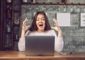 girl looks at laptop with horror, girl terrified