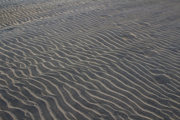 Black and yellow beach sand in wave pattern (Gran Canaria, Spain)