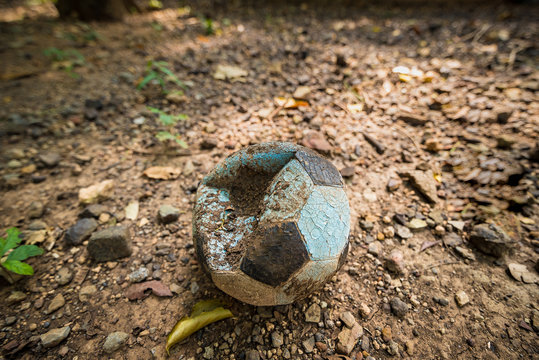 Old deflated soccer ball on the field.Thailand.