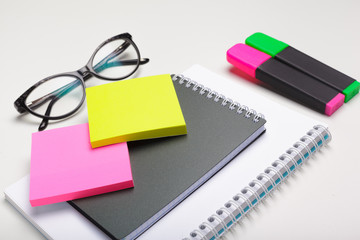 Sticky notes with markers, colored pens, paper clips laying on a table