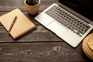 Office table with blank notebook and laptop / Coffee cup