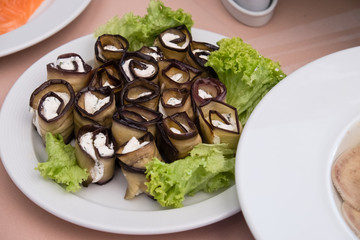 Eggplant rolls with cheese on the table with snacks