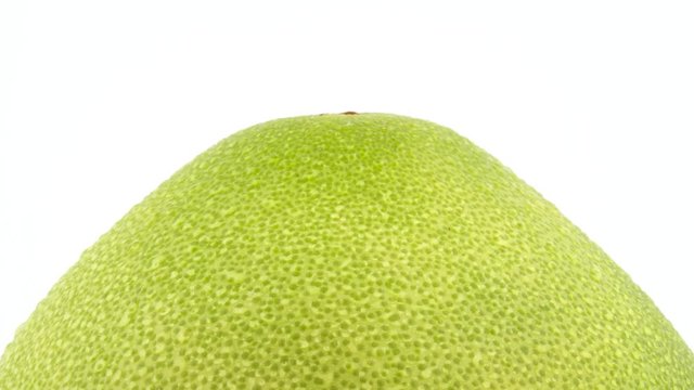 Upper part of pomelo fruit with water drops. Rotating on the turntable. Isolated on the white background. Close-up. Macro.