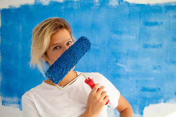 woman painting a wall with paint roller
