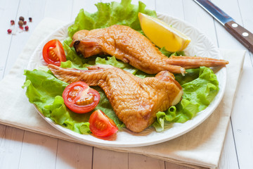 Smoked chicken wings with fresh lettuce tomato and lemon