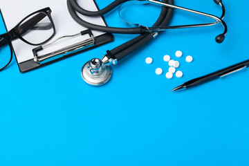 Stethoscope, clipboard and pills, closeup. Medical equipment