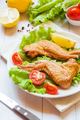 Smoked chicken wings with fresh lettuce tomato and lemon