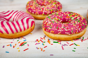 Pink donuts on a wooden background.