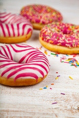 Pink donuts on a wooden background.