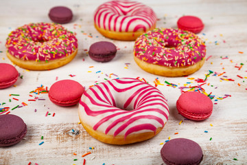 Donuts and macaroons on a wooden background