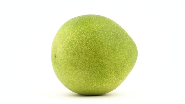 One big shaddock pomelo fruit with water drops. Lies on the side. Rotating. Isolated on the white background. Close-up. Macro.