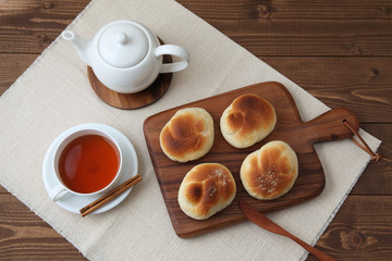 木のまな板にのせた 焼きたて パン 紅茶 ポット テーブル