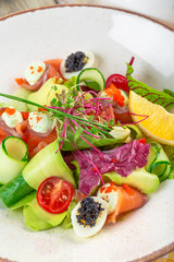 A delicious smoked salmon garden salad with smoked salmon, mixed baby greens