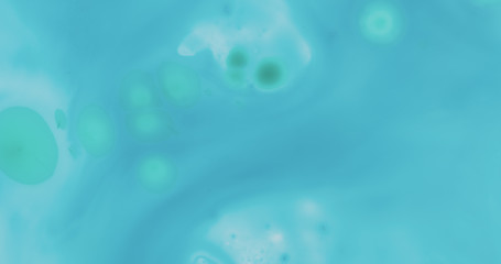 green ink spreads on blue ink on plastic background