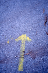 Gelber Pfeil auf Asphalt